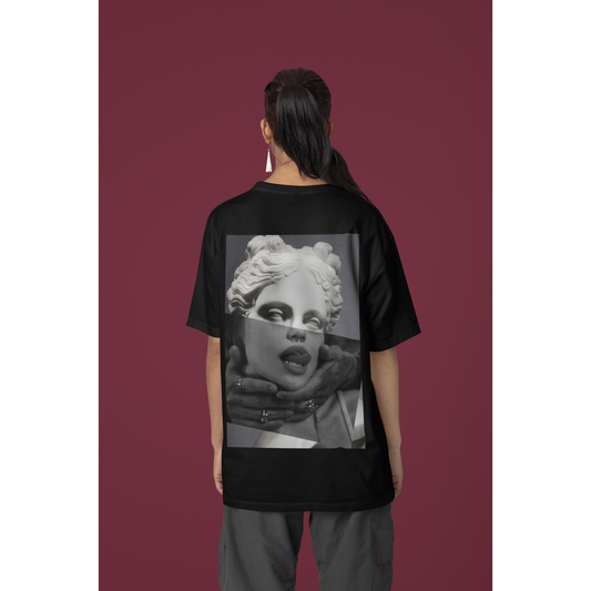 Female model wearing plain black surreal statue statement t-shirt in studio setting, unisex dark luxury streetwear tee featuring clean minimalist front design and bold surreal back artwork