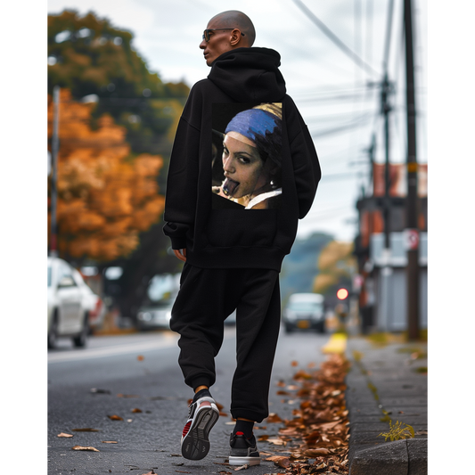 Lifestyle shot of model walking outdoors wearing black Classical Girl with a Pearl unfiltered collage back graphic hoodie, dark luxury streetwear hoodie with bold classical artwork and minimalist front