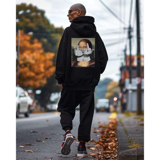 Male model wearing a black unisex hoodie walking on a city street, back view, featuring a bold Mona Lisa middle finger collage graphic printed on the back in dark luxury streetwear style.