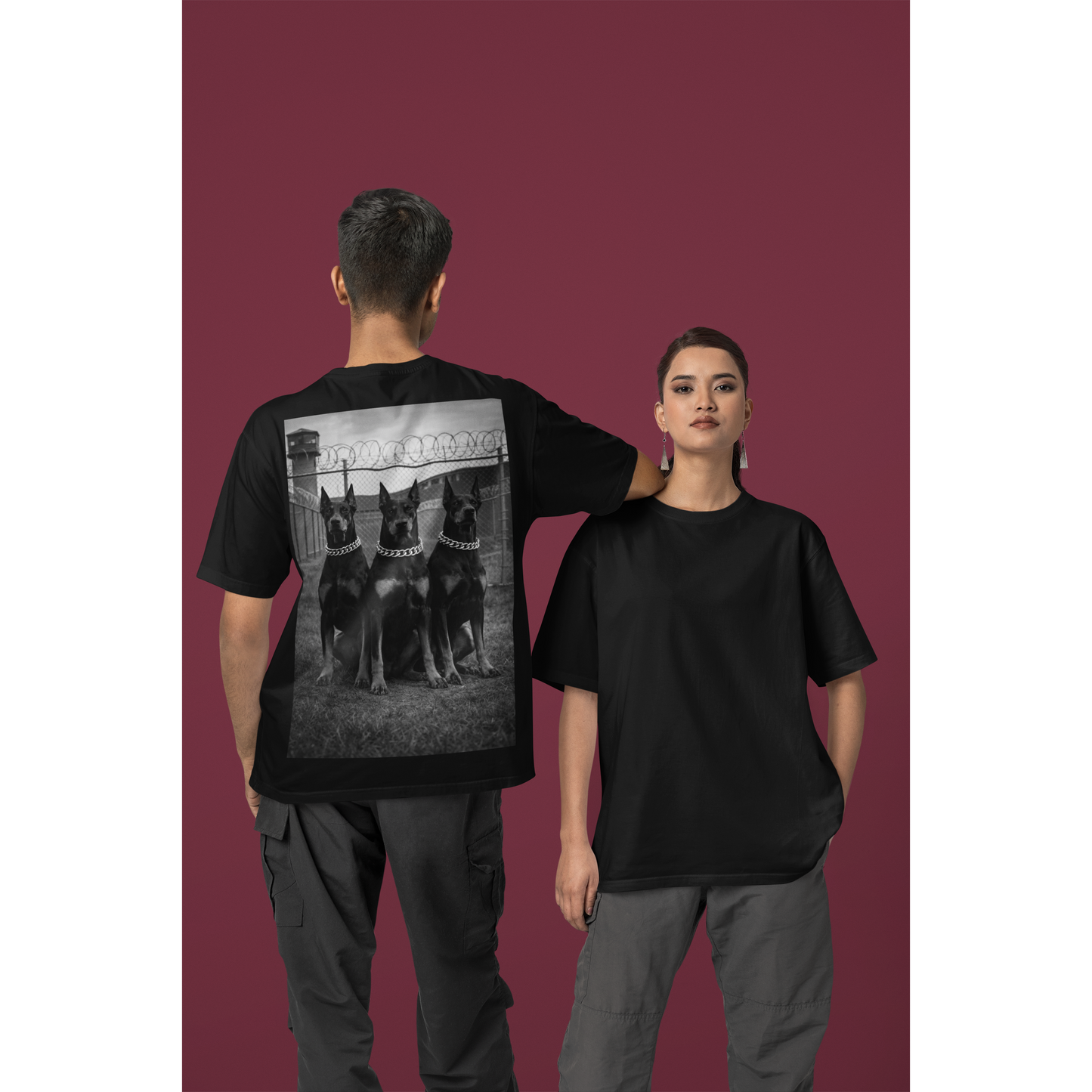 Black unisex streetwear t-shirt worn by male and female models, back view showcasing Doberman trio artwork, dark motivational fashion symbolizing strength, loyalty, and endurance