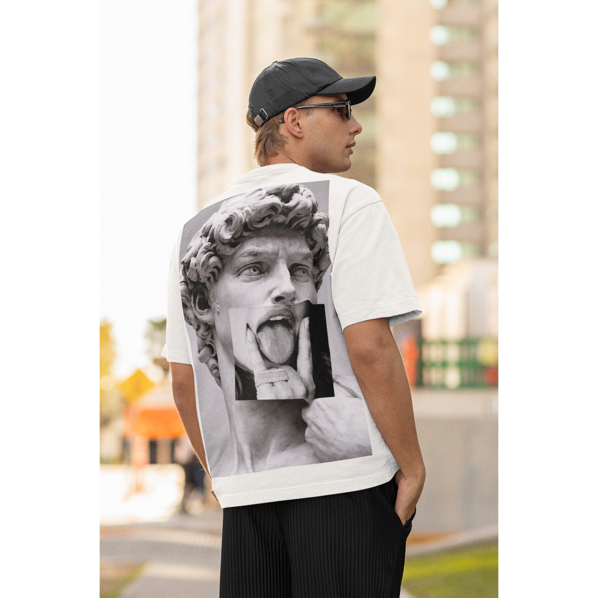 Male model wearing white graphic t-shirt with David statue grunge collage back artwork, urban gothic streetwear fashion, statement art t-shirt outfit