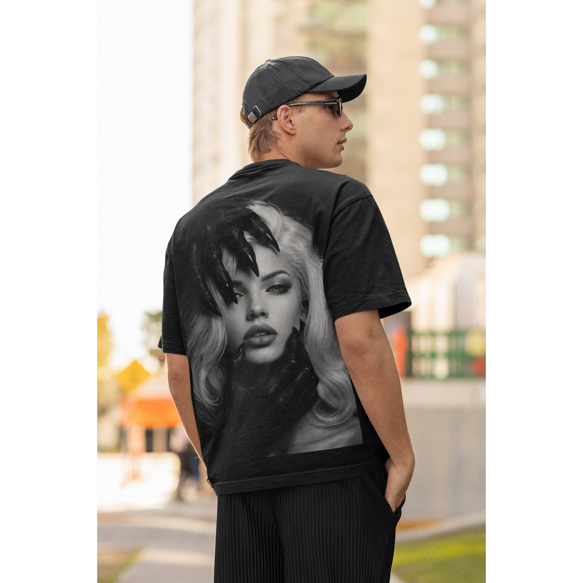 Male model wearing black dark feminine back graphic t-shirt outdoors, unisex gothic portrait statement tee featuring dark feminine portrait artwork printed on the back