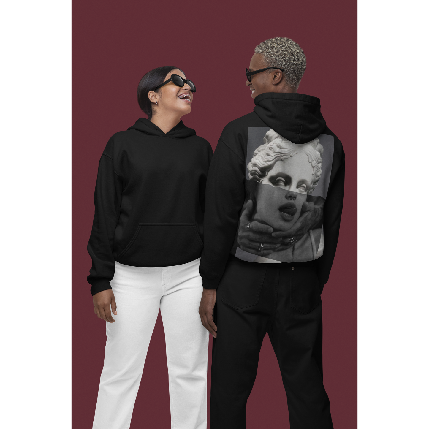 Black surreal statue back graphic hoodie shown on male and female models with front and back views, unisex dark luxury statement hoodie featuring surreal classical statue collage artwork on the back and clean minimalist front