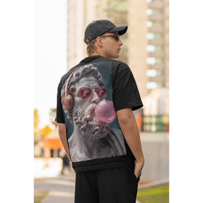 Lifestyle shot of male model wearing black classical statue headphones bubblegum back graphic t-shirt outdoors, dark luxury streetwear tee featuring marble statue with headphones and pink bubblegum and clean black front