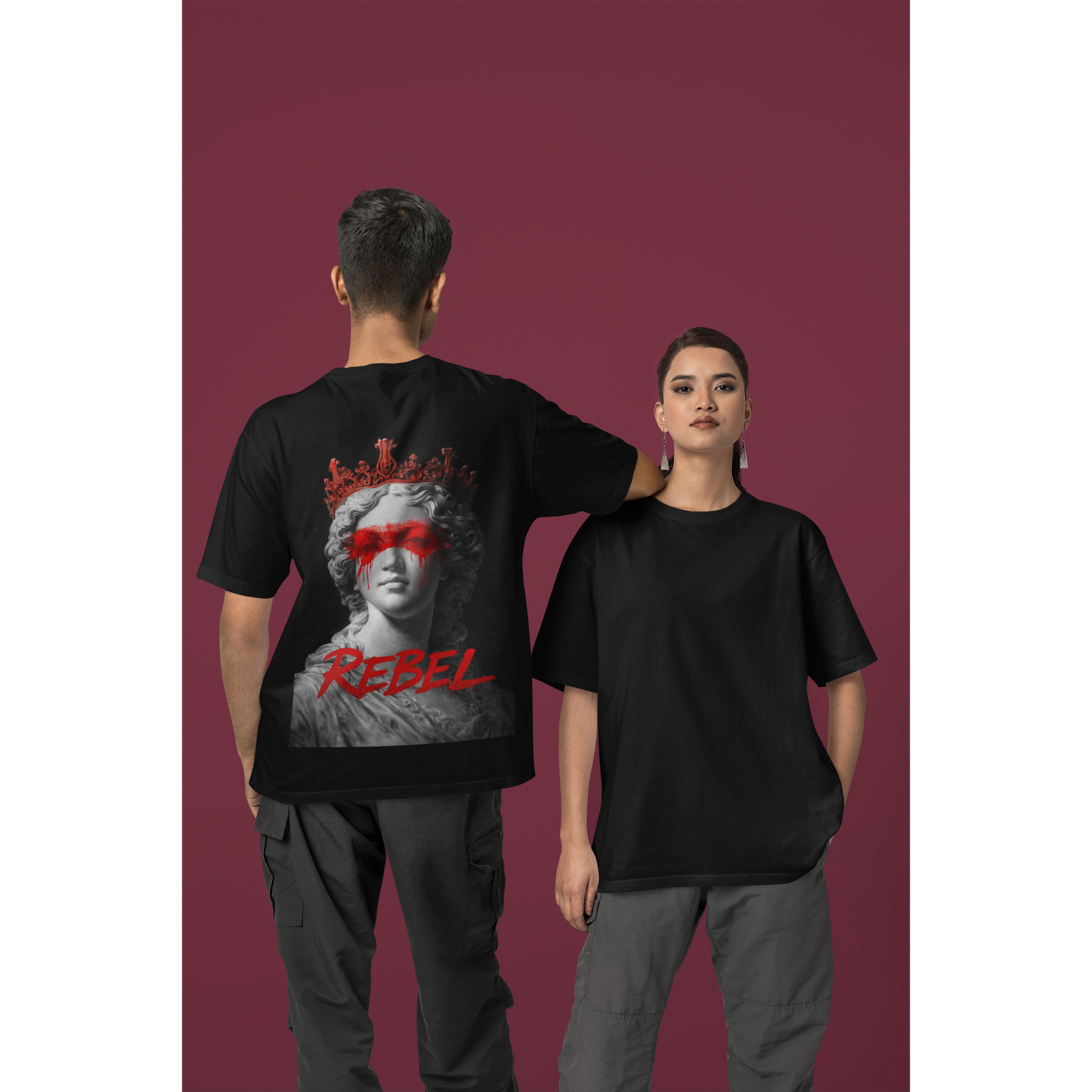 Unisex Rebel black t-shirt shown on male and female models, featuring clean minimalist front and bold back graphic of classical marble statue with red crown, red paint across the eyes, and “REBEL” statement text