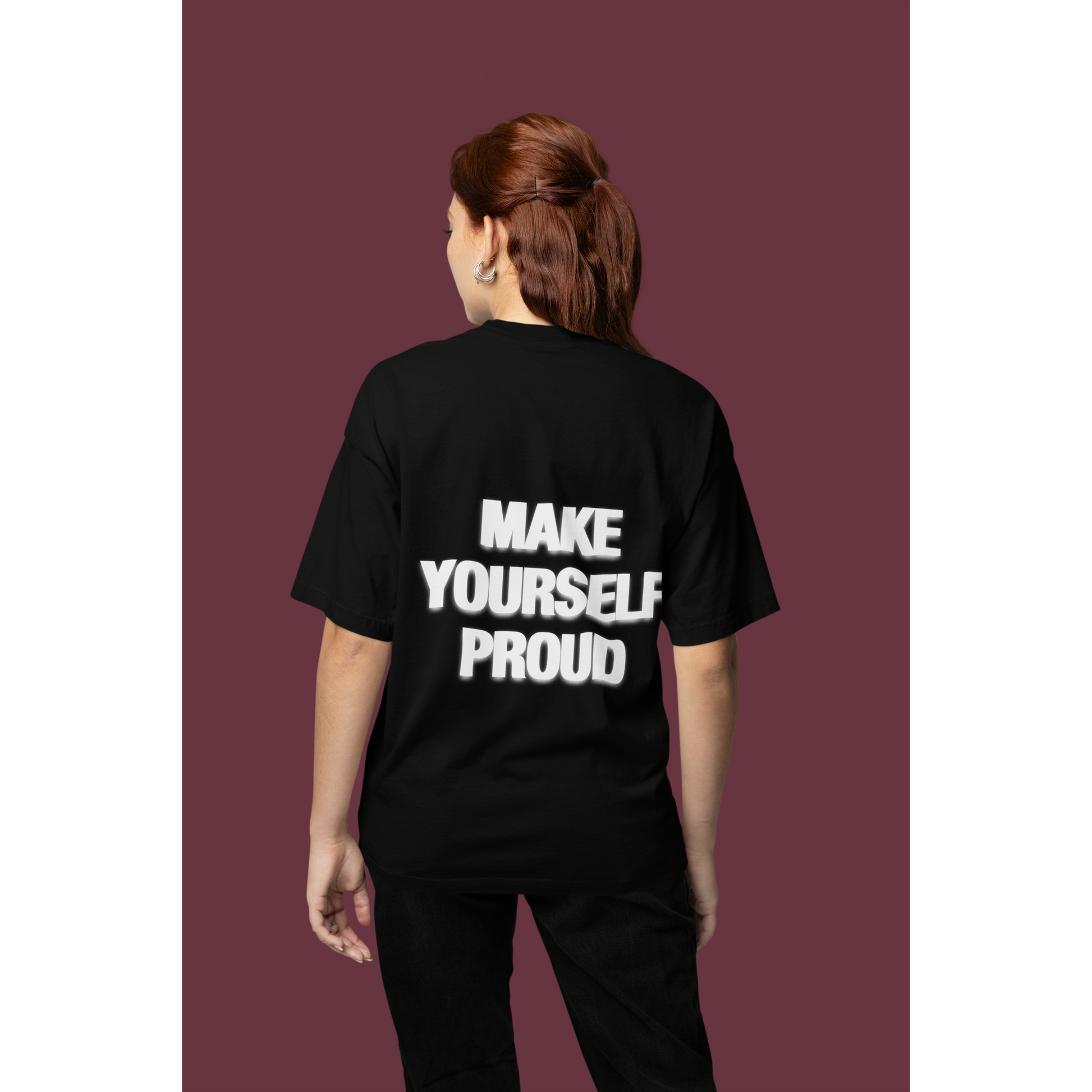 Person wearing a black t-shirt with 'MAKE YOURSELF PROUD' text on the back Back view of black graphic t-shirt with bold statement text
