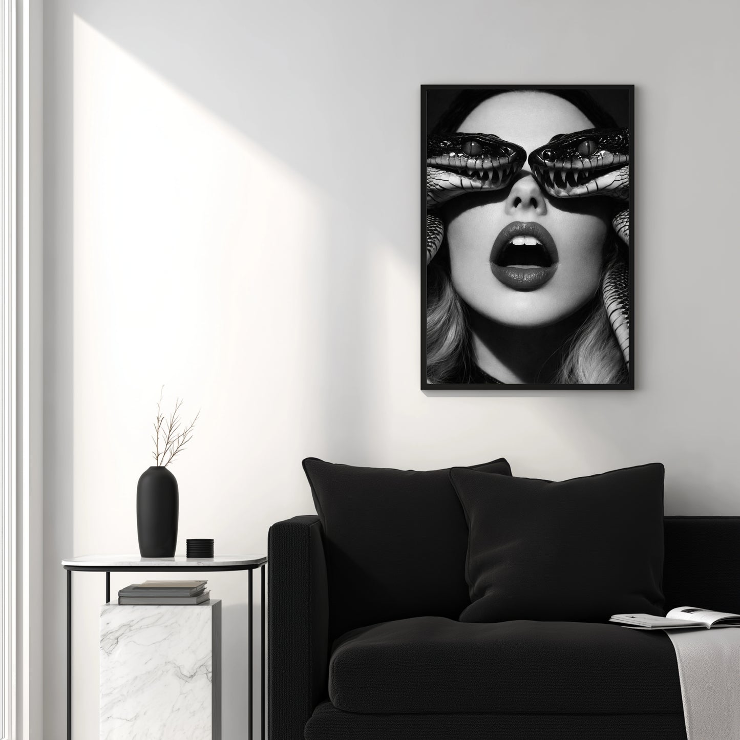 Contemporary black and white snake portrait wall art above black sofa in minimalist interior setting