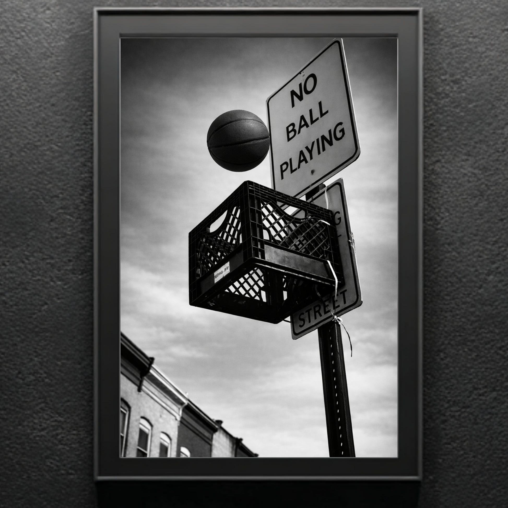 Close up black and white street basketball wall art in black frame, milk crate hoop mounted under no ball playing street sign urban photography print
