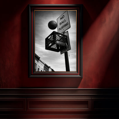 Black and white urban basketball photography in black frame on deep red wall, milk crate hoop beneath no ball playing sign modern statement artwork