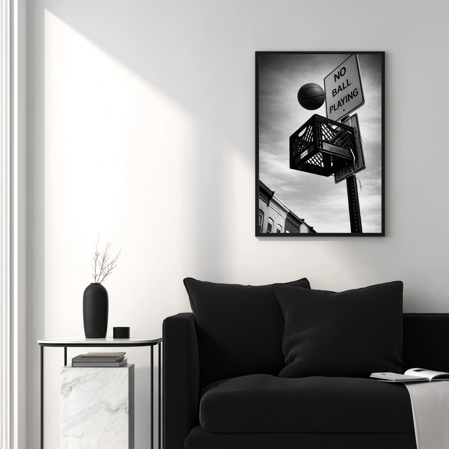 Black and white urban basketball wall art above black couch, milk crate hoop and no ball playing sign modern minimalist interior decor