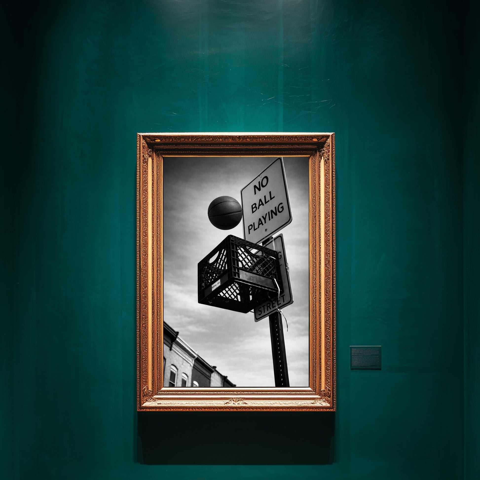 Black and white street basketball wall art framed in ornate gold on emerald green gallery wall, milk crate hoop under “No Ball Playing” sign urban statement decor