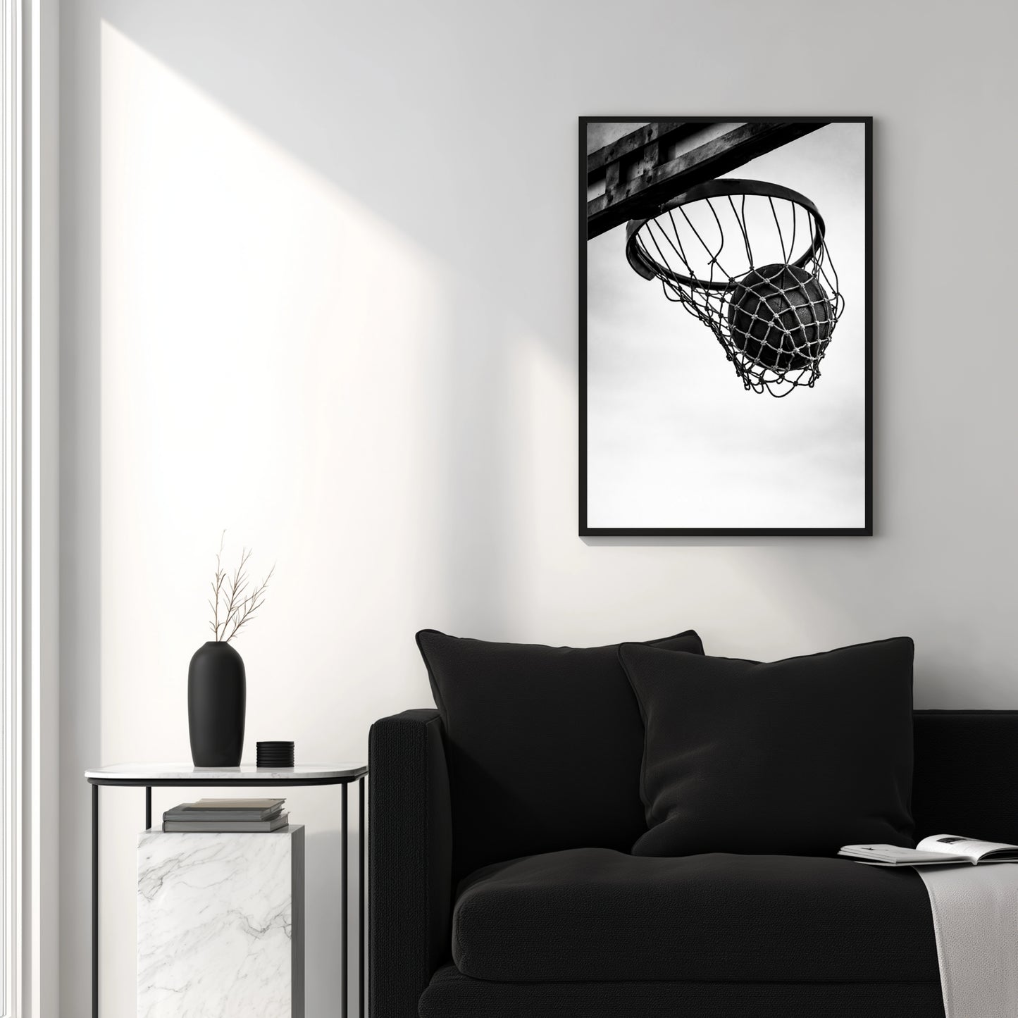 Black and white basketball hoop wall art in modern white living room above black sofa, clean minimal sports photography decor