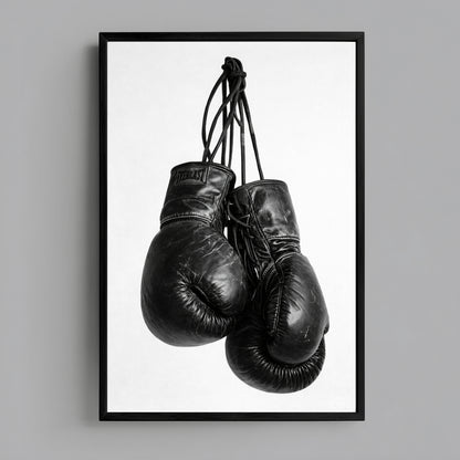 Black and white boxing gloves wall art minimalist sports photography print featuring hanging worn gloves on clean white background