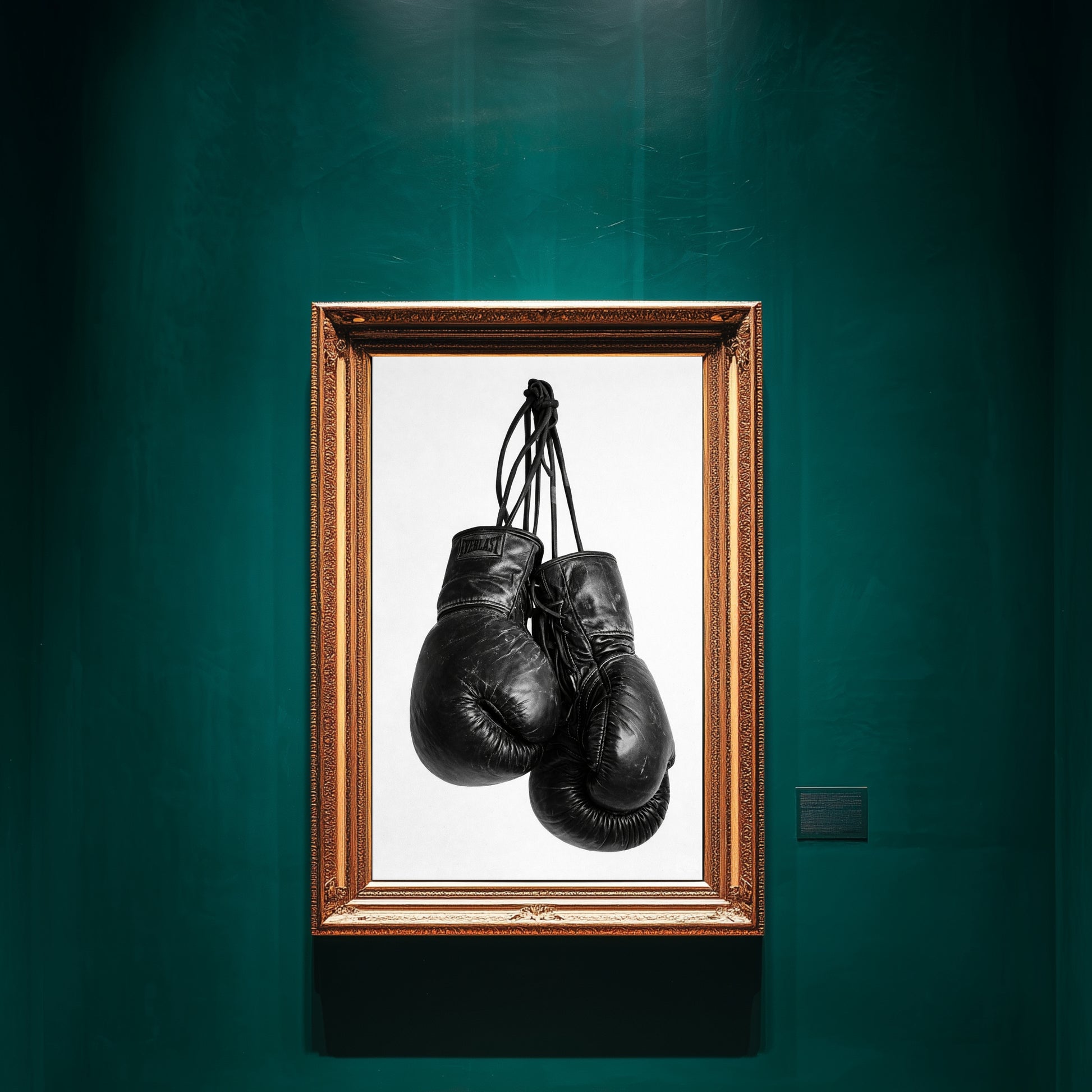 Black and white boxing gloves wall art framed in ornate gold frame on deep green gallery wall, minimalist sports photography print for gym decor and motivational office wall art