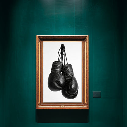 Black and white boxing gloves wall art framed in ornate gold frame on deep green gallery wall, minimalist sports photography print for gym decor and motivational office wall art