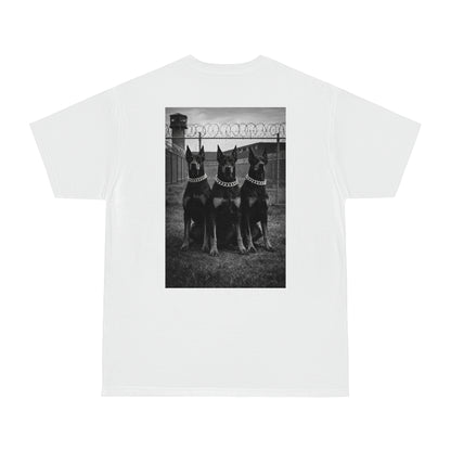 White unisex streetwear t-shirt with black and white Doberman trio back graphic, dark motivational artwork symbolizing discipline, loyalty, strength, and endurance
